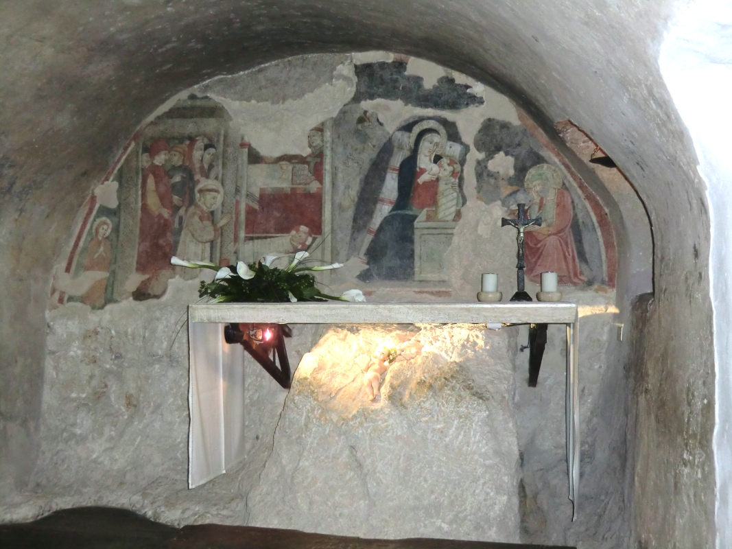 Die Höhle, in der Franziskus mit seinen Brüdern 1223 das ersteFest der Geburt des Herrn mit einer Krippe feierte, im Kloster bei Grecchio. Das Fresko, Giotto-Schule aus dem 14. Jahrhundert, zeigt rechts die Geburt im Stall von Betlehem, links wie Franziskus, vor dem Kind knieend, mit Würdenträgern feiert.