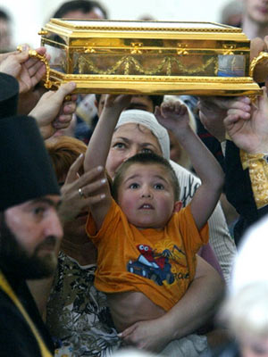 Ein Kind streckt sich während einer Prozession in Vladikavkaz zu dem Schrein mit der rechten Hand Johannes'
