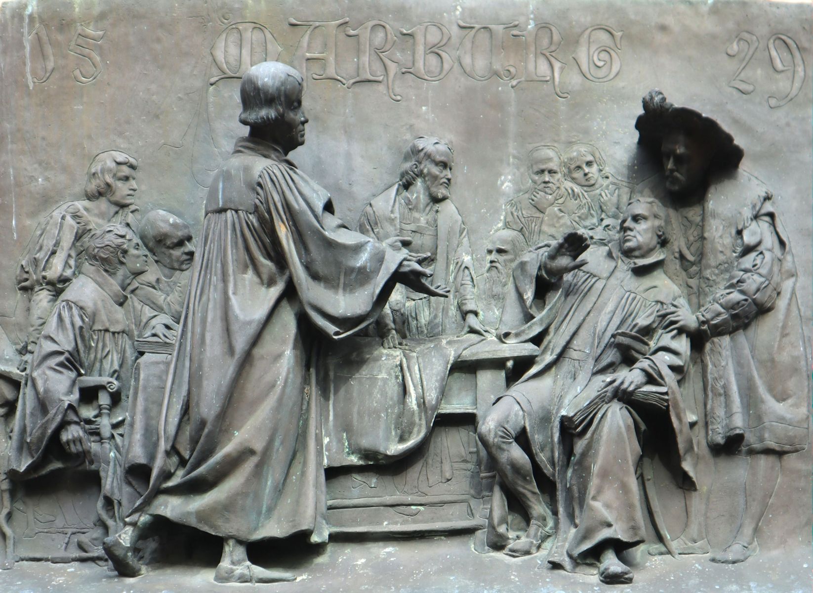 Relief: Philipp beim „Marburger Religionsgespräch„, an der Martinskirche in Kassel